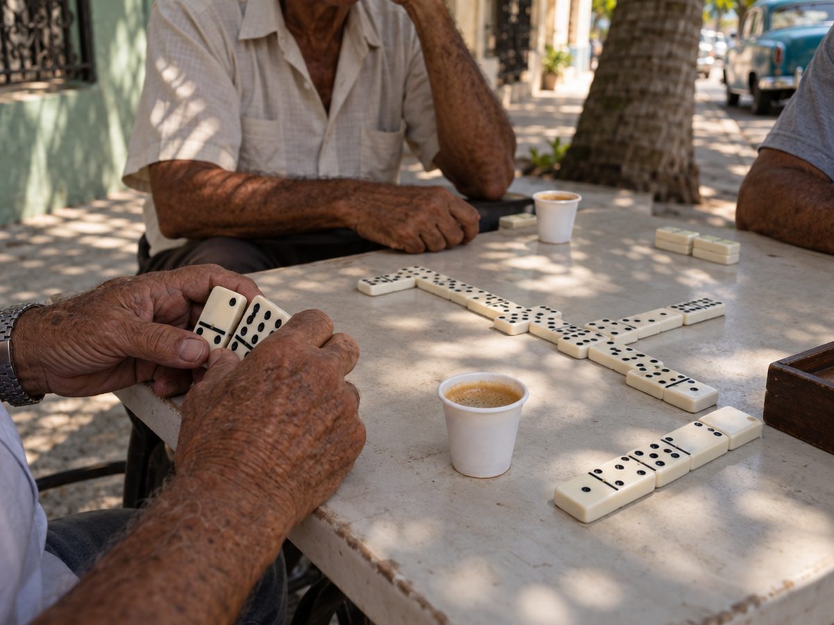 A game of dominoes and two small cups of Cuban coffee on a sidewalk table